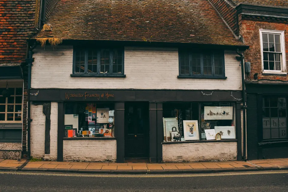 Small white storefront with dark frames and a tiled roof